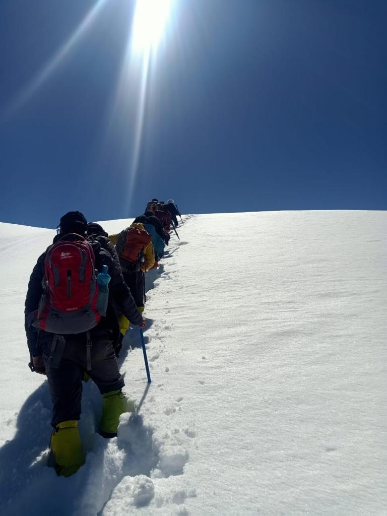 Trekkers climbing a snow ridge